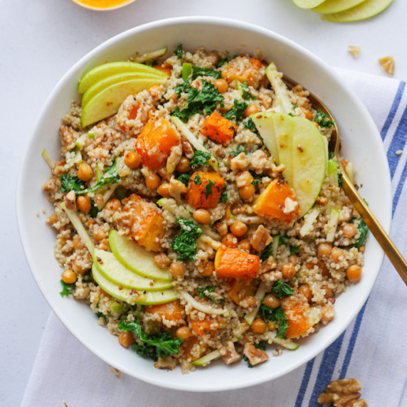 Roast Butternut Squash Salad with Quinoa and Apple in a white bowl with a gold fork.