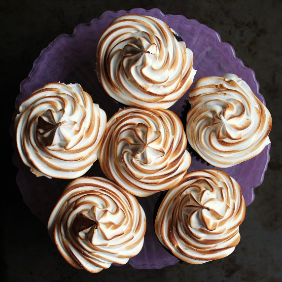 A pink plate of six S'mores Cupcakes with toasted marshmallow frosting