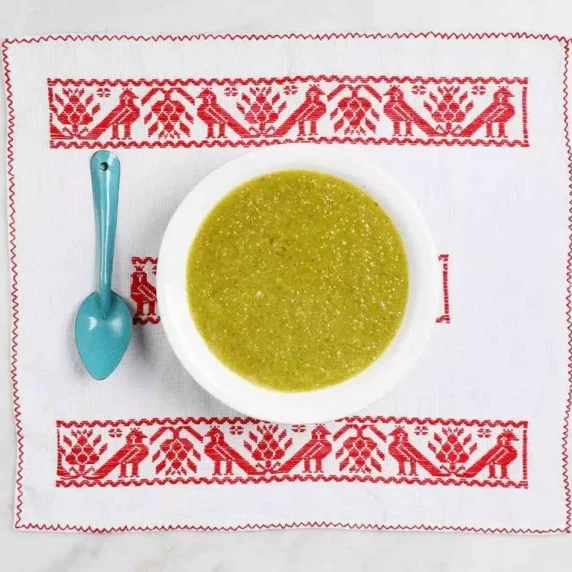 Authentic Salsa verde or green sauce serve in a white bowl with blue spoon
