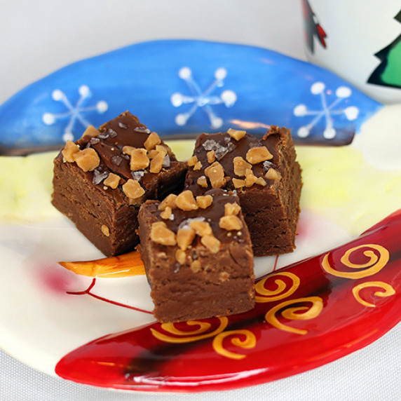 Three pieces of salted caramel toffee fudge arranged on a Christmas plate against a white background