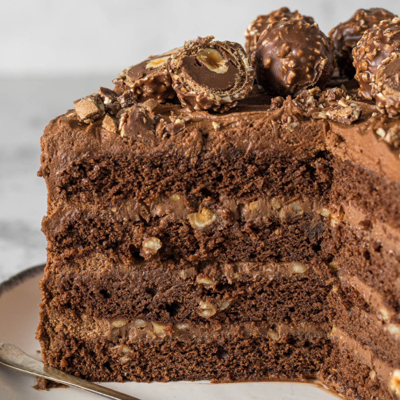 Sliced Ferrero Rocher cake showing layers of cake, ganache and frosting.