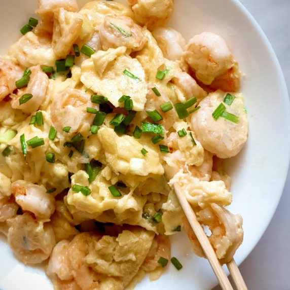 Shrimp and Egg Recipe on a white plate being eaten with chopsticks.