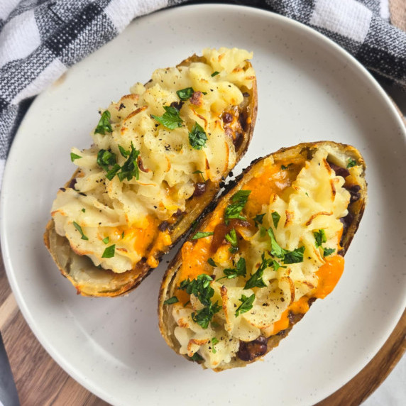 Potato skins with pops of green parsley against a checkered towel.
