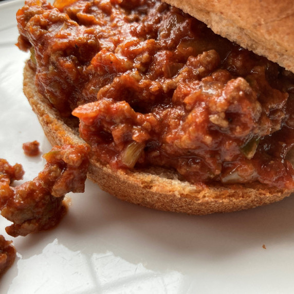 Sloppy joe sandwich on a white plate.