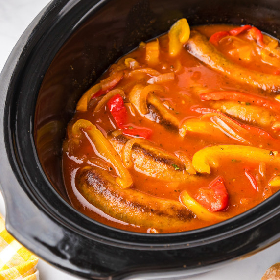 Cooked Italian sausage, peppers and onions in a tomato sauce in a crock pot.