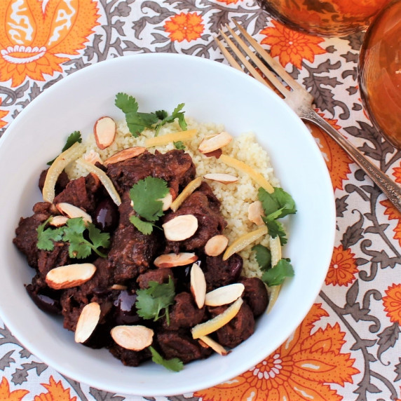 Slow Cooker Moroccan Lamb Tagine over couscous in a white bowl.