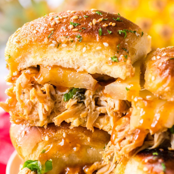 Side close up view of a bbq shredded chicken slider topped with pineapple.