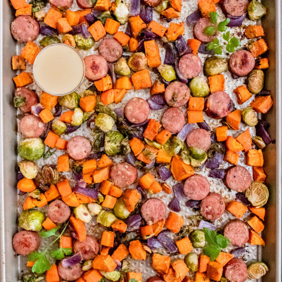 Cooked sheet pan dinner of potatoes, onion, brussel sprouts, and sausage