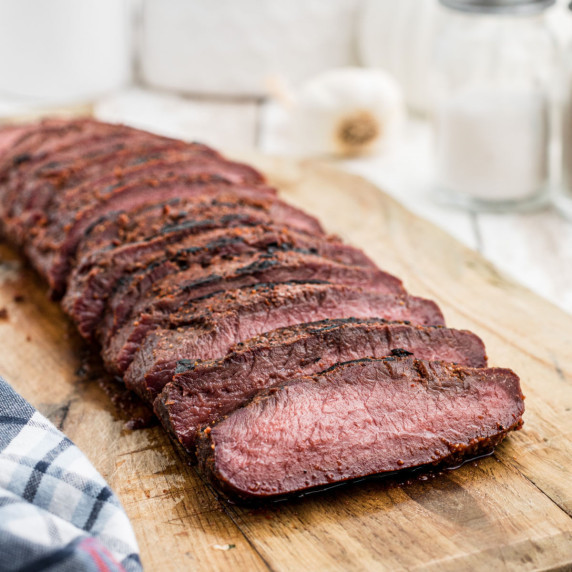 a length of smoked venison backstrap laid out and sliced.