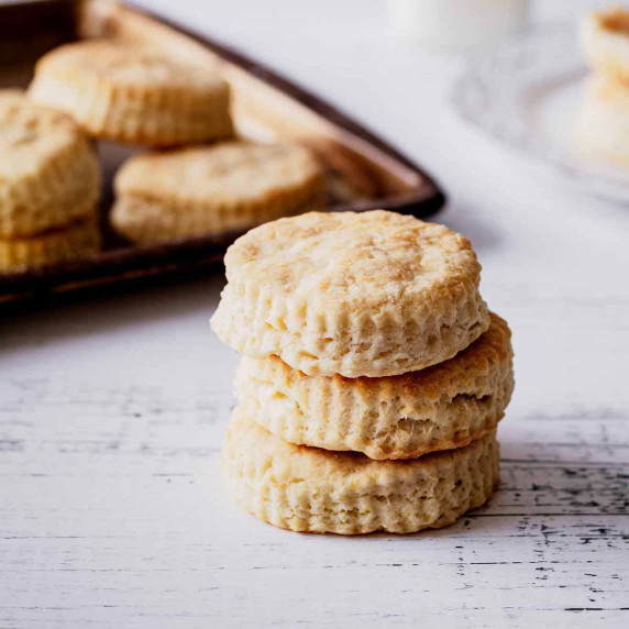 Stack of sour cream biscuits on a white wood surface