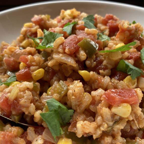 Spanish rice garnished with minced cilantro in a white bowl.