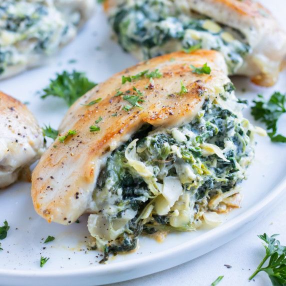 Spinach Artichoke Stuffed Chicken Breasts RECIPE served on a white plate. 
