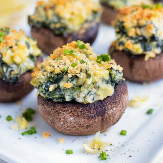 Spinach Stuffed Mushroom RECIPE placed on a white platter and garnish.