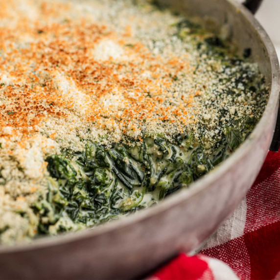 Close up of a pan filled with creamy spinach madeleine.
