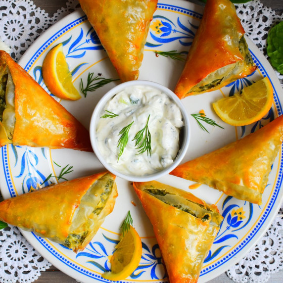 Golden filo pastry parcels stuffed with spinach, onion and feta cheese served with a Tzatziki dip