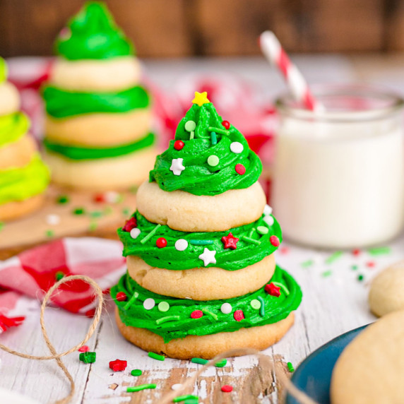 a stack of sugar cookies held together with green frosting and sprinkles for a xmas tree