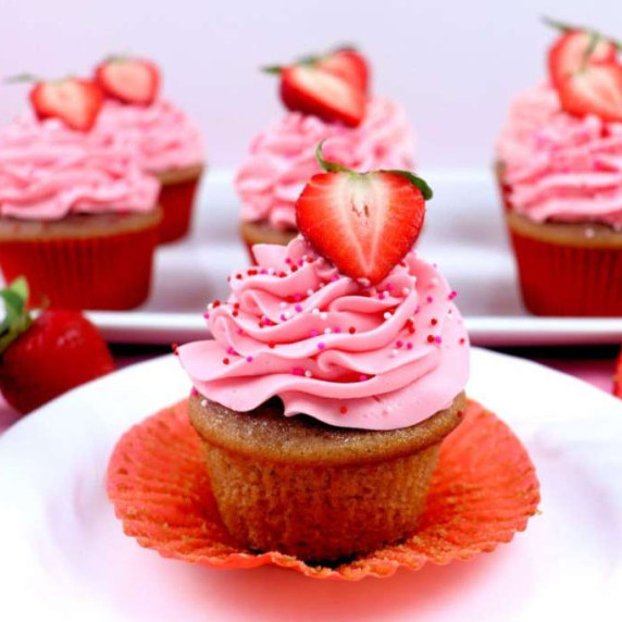 Strawberry cupcake with strawberry mascarpone frosting and a sliced strawberry decoration.