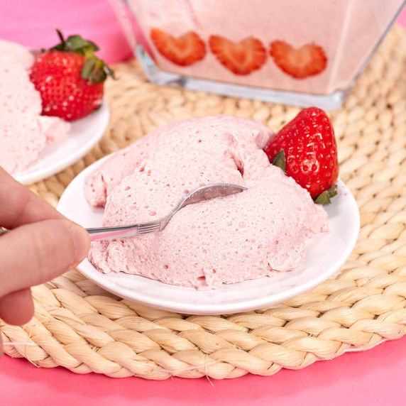 Fluff strawberry mousse on plate with spoon.