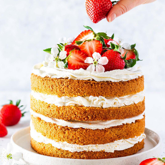 Layered Chantilly Cake decorated with fresh strawberries