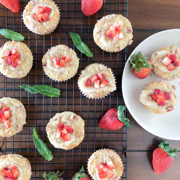 Strawberry Rhubarb Cream Cheese muffins arranged on a cooling rack and in a white plate