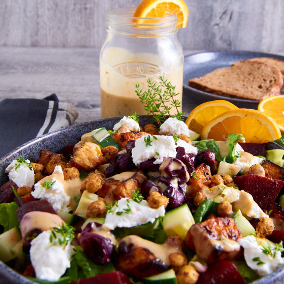 Salad bowl with roasted sweet potatoes and grapes, greens, beets, crispy chickpeas and goats cheese.