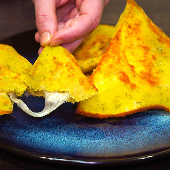 Ruddy potato triangles with cheese on a plate.