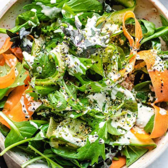 Tatsoi, mixed greens, cucumber, carrots and ranch dressing in a salad bowl