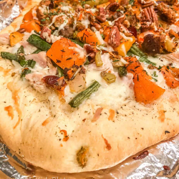 Close up of pizza with squash, green beans, stuffing and turkey