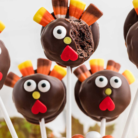 Close up of some Thanksgiving cake pops, one with a bite missing.