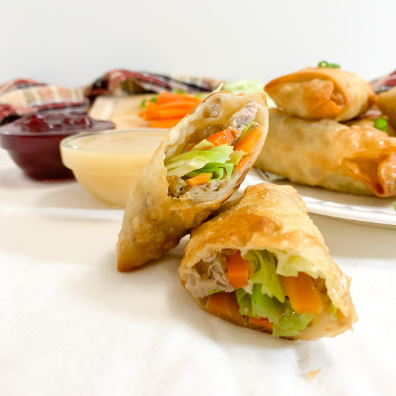 cross section of thanksgiving leftover egg rolls with cranberry sauce and gravy dipping sauces