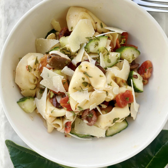 Cheese tortellini served with cucumbers, tomatoes, olives, fresh parmesan, and red wine vinegar. 