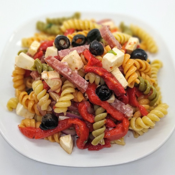 Tri color rotini pasta prepared al dente and mixed with oil, vinegar, red onion, fresh mozzarella, r