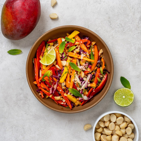 Tropical macadamia mango slaw in a brown bowl