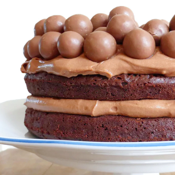 close up of a chocolate cake with Maltesers on a white plate