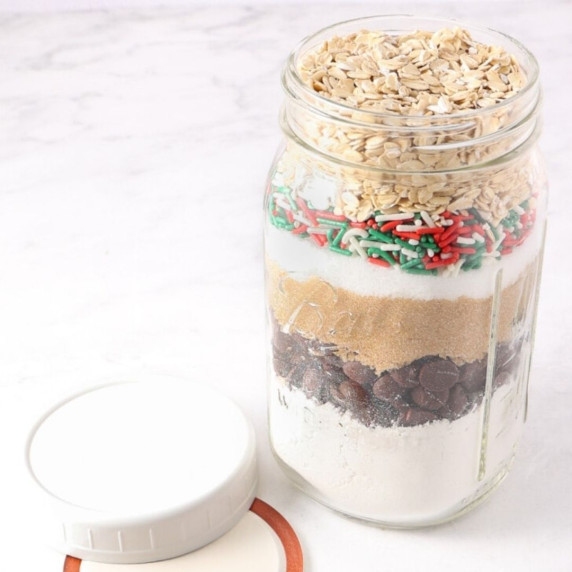 Cookie mix or dry ingredients layered in a glass jar on a white countertop