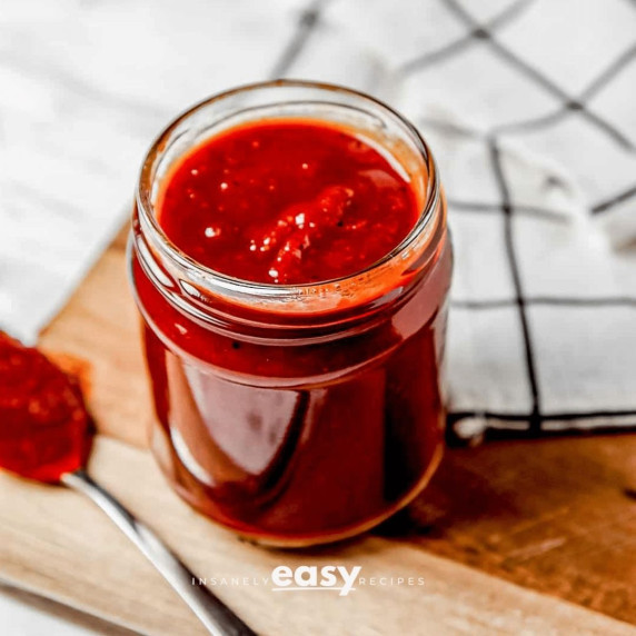 Vegan Barbeque sauce in a small glass jar and on a spoon