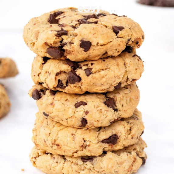 five stacked vegan oatmeal chocolate chip cookies on a white countertop