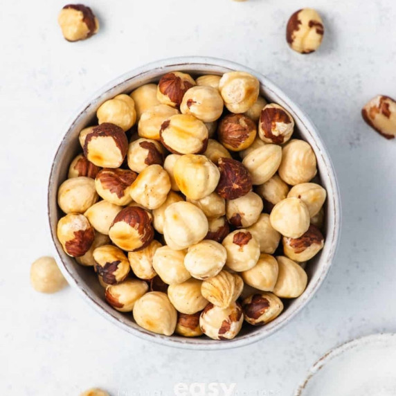 Roasted hazelnuts in a white bowl