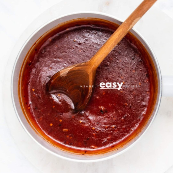 Sweet and spicy sauce or dragon sauce in a white bowl with a wooden ladle