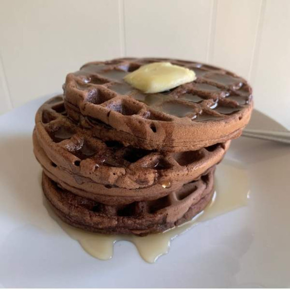 homemade chocolate waffles topped with maple syrup and butter 