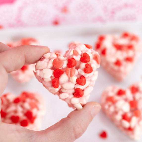 Heart-shaped pink rice krispies treat with Valentine's sprinkles.