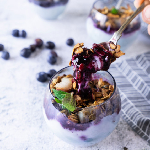 Vanilla yogurt with blueberry compote in glass.