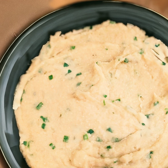 cauliflower white bean mash with roasted garlic and chives in a bowl on a countertop