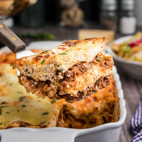 Close up of a slice of venison lasagna being lifted out of a dish.