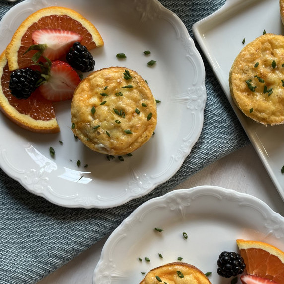 Egg muffins on a white plate garnished with fresh chives. 