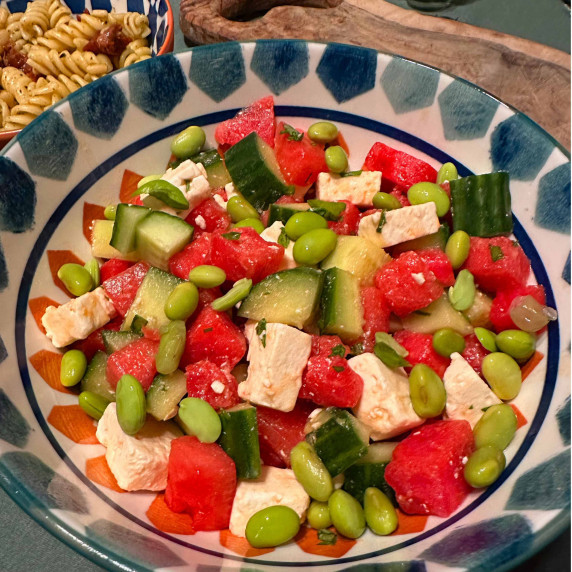 Watermelon broad beans cucumber and feta as a salad in a bowl ready to be eaten