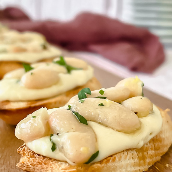 Crostini with white bean on a wooden tray