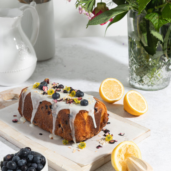 Lemon and blueberry loaf on a wooden board ready to slice