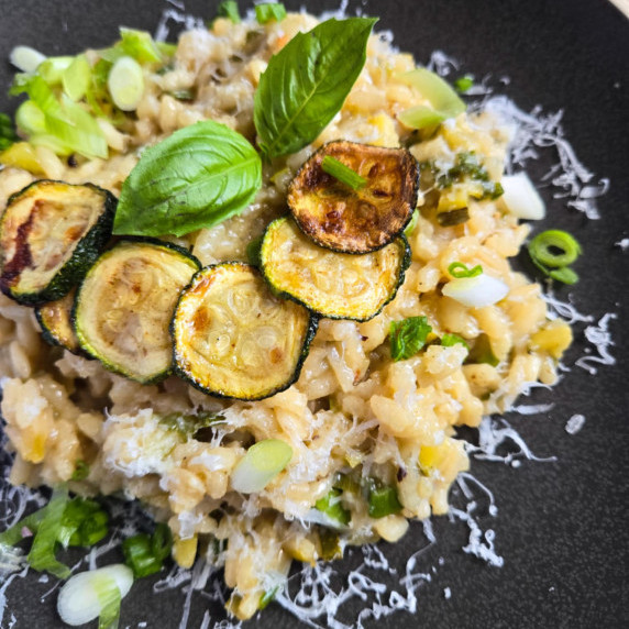 Creamy risotto with pops of green and golden brown zucchini rounds.