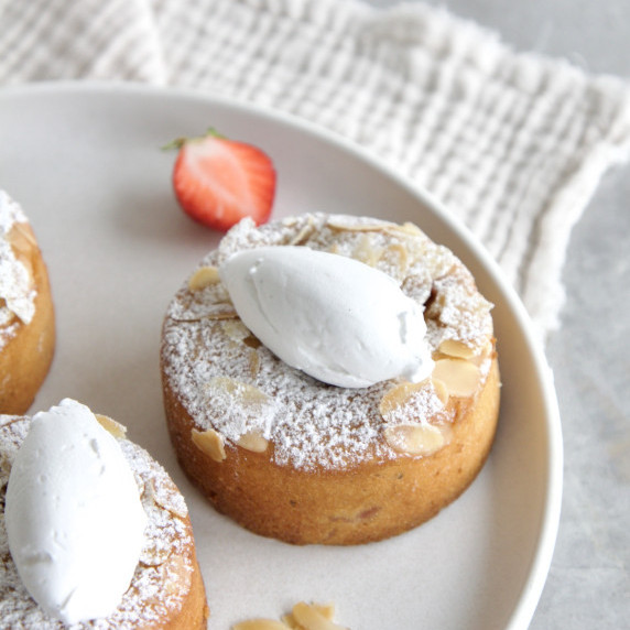 vegan strawberries almond cakes with a quenelle of cream on top, dusting of icing sugar 